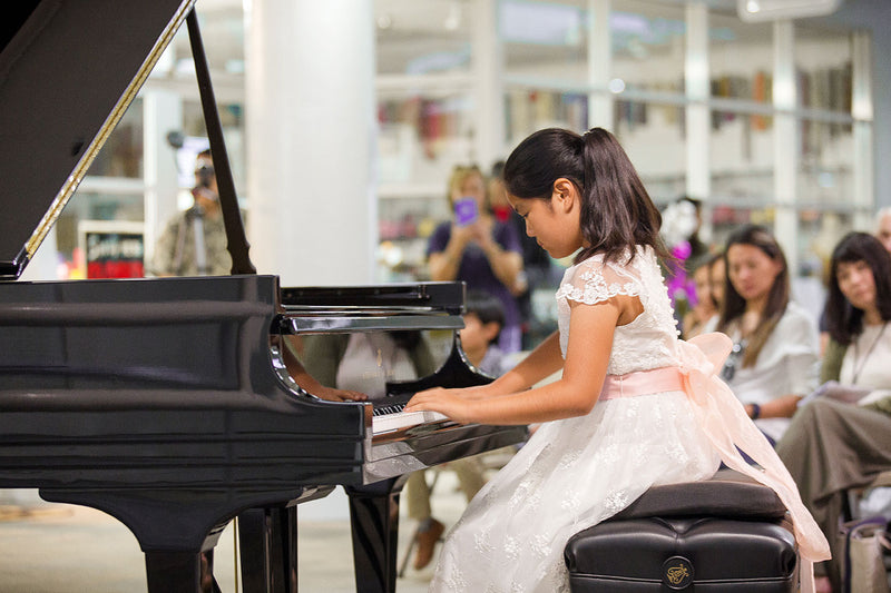 Girl playing on a Steinway grand piano