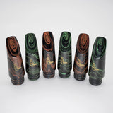 The B. Corbin Signature Marbled Hard Rubber Bb Clarinet Mouthpieces - Four mouthpieces standing up-right, alternating between red marble and green marble colors.