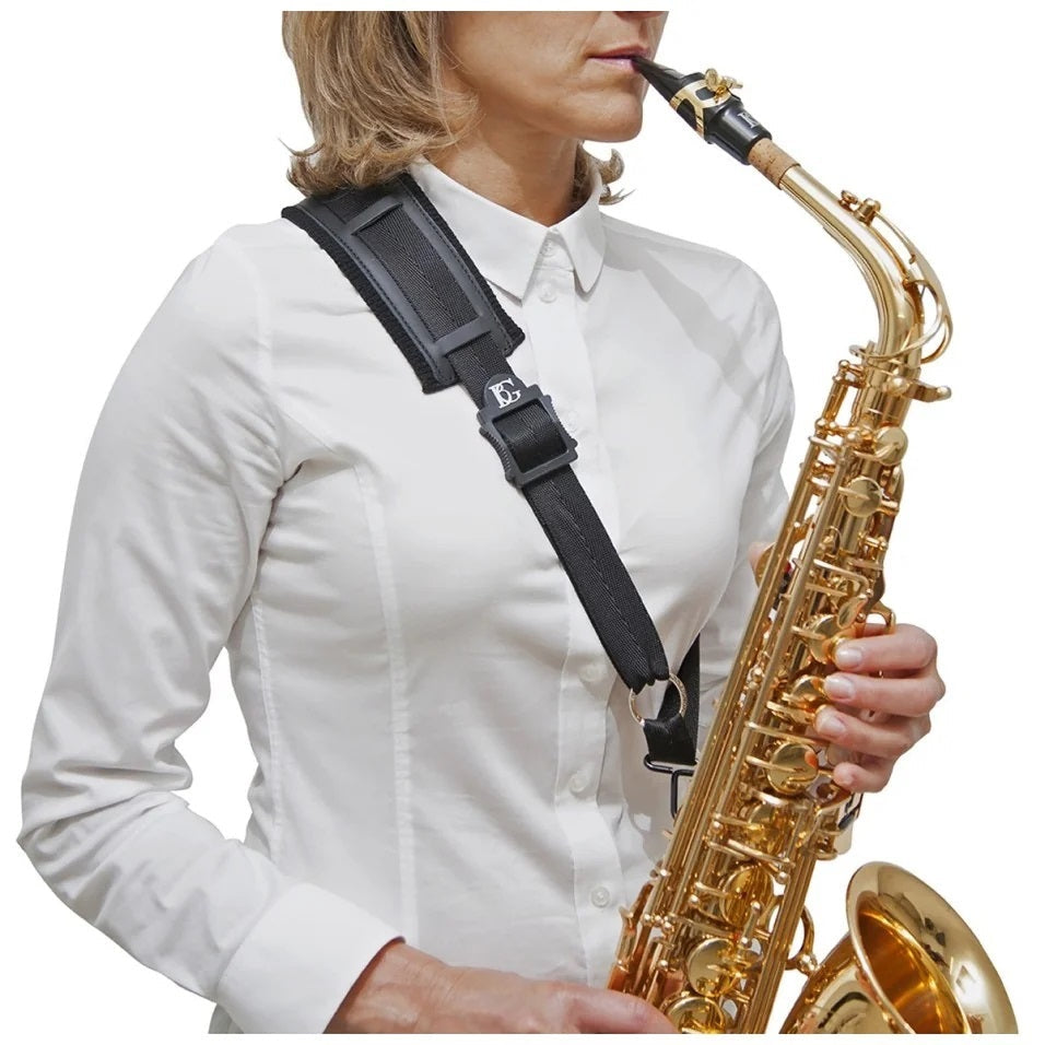 A female model holding a saxophone with the BG France S02M or S03M saxophone shoulder strap