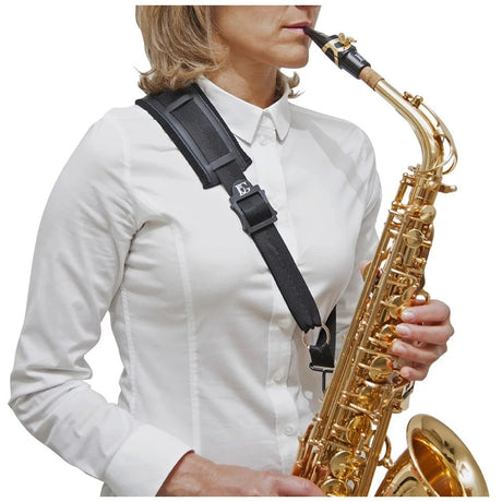 A female model holding a saxophone with the BG France S02M or S03M saxophone shoulder strap