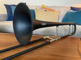 Butler Lemondrop Small Bore Tenor Trombone -  sitting on a coffee table with a couch behind it