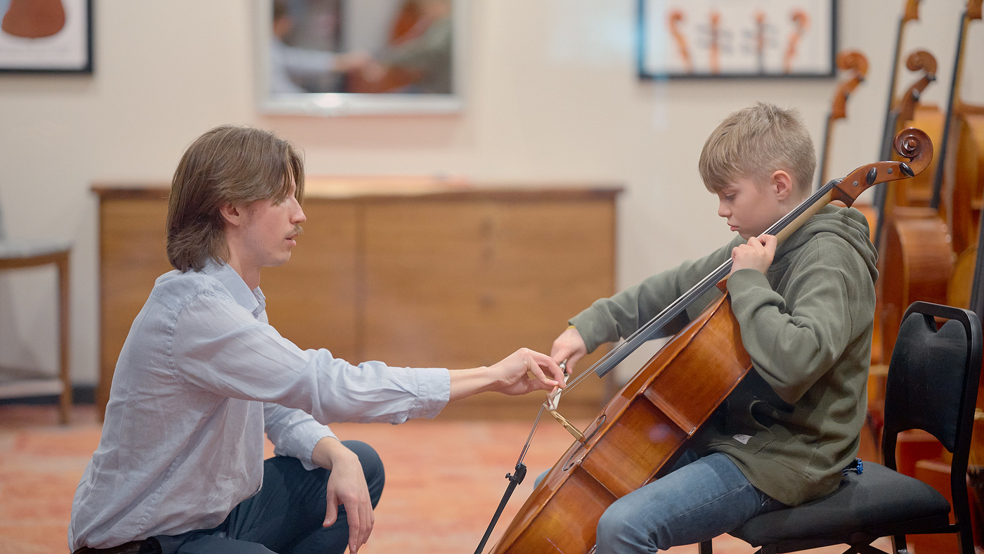 teacher helping student play an instrument