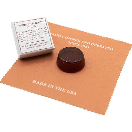 The Sherman Violin Rosin out of its cardboard packaged and with its silk cloth laid out flat.